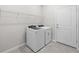 Functional laundry area includes modern appliances and convenient wire shelving for storage solutions at 2731 Winding Creek Trl, North Port, FL 34289