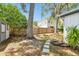 View of backyard with shed, tree coverage, garden and partial home elevation at 3202 W Coachman Ave, Tampa, FL 33611