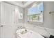 White soaking tub beneath the window and marble tile provide a relaxing experience at 3202 W Coachman Ave, Tampa, FL 33611