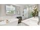 Spa bathroom features soaking tub, marble tile, glass enclosed shower, and modern fixtures at 3202 W Coachman Ave, Tampa, FL 33611