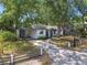 Charming single-story home with a covered carport and lush landscaping providing ample shade and curb appeal at 3202 W Coachman Ave, Tampa, FL 33611