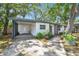 Inviting single-story home with a covered carport, a well-maintained lawn, and a brick exterior at 3202 W Coachman Ave, Tampa, FL 33611