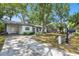 Charming single-story home featuring a spacious front yard with mature trees, a covered carport and a quaint picket fence at 3202 W Coachman Ave, Tampa, FL 33611