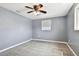 A tranquil bedroom with soft grey walls, neutral carpet, a ceiling fan, and a sunny window at 3257 Masonville Loop, Holiday, FL 34691