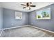A cozy bedroom painted in calming blue tones, featuring neutral carpeting and a ceiling fan at 3257 Masonville Loop, Holiday, FL 34691