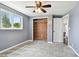 A serene bedroom featuring a wooden closet, soft grey walls, and a view of lush greenery outside at 3257 Masonville Loop, Holiday, FL 34691