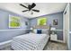 Comfortable bedroom with ceiling fan, two windows with backyard view, and overhead lighting at 3257 Masonville Loop, Holiday, FL 34691