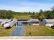 Exterior view of the home featuring solar panels, a long driveway and a manicured lawn at 3257 Masonville Loop, Holiday, FL 34691