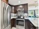 Stylish kitchen with stainless steel appliances, granite counters, and dark wood cabinetry at 3257 Masonville Loop, Holiday, FL 34691