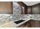 Close-up of the kitchen featuring granite countertops, mosaic backsplash, and modern faucet at 3257 Masonville Loop, Holiday, FL 34691