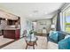 Open living space with dark wood floors, an area rug, and a glimpse into the modern kitchen at 3257 Masonville Loop, Holiday, FL 34691
