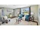 Bright living room with a cozy sofa, plush rug, and a view of the outdoors through a large window at 3257 Masonville Loop, Holiday, FL 34691