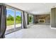 Bright living room featuring a brick fireplace, large windows, and sliding door to the patio at 3257 Masonville Loop, Holiday, FL 34691