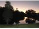 Sunset view of trees reflecting in tranquil pond at dusk at 337 Woodlake Wynde, Oldsmar, FL 34677