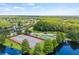 Aerial of the community playground, tennis, and basketball courts near lake and lush woods at 3810 Darston St, Palm Harbor, FL 34685