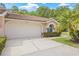 Inviting single-story home with a well-maintained lawn, a two-car garage, and a charming barrel tile roof at 3810 Darston St, Palm Harbor, FL 34685