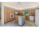 Bright kitchen with wood cabinets, granite countertops, an island with seating, and stone flooring at 3810 Darston St, Palm Harbor, FL 34685
