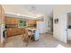 Bright kitchen with wood cabinets, granite countertops, an island with seating, and stone flooring at 3810 Darston St, Palm Harbor, FL 34685