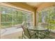 Outdoor patio with a screened-in porch and views of the wooded backyard at 3810 Darston St, Palm Harbor, FL 34685