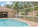 Screened in pool with brick trim and ample space for outdoor lounging in a well-kept community at 3810 Darston St, Palm Harbor, FL 34685