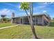 View of the rear of the property, featuring a screened in porch and lush green grass at 3901 E Eden Roc Cir, Tampa, FL 33634