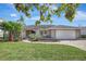 Charming single-story home with lush landscaping, paved driveway, and an attached two car garage at 3901 E Eden Roc Cir, Tampa, FL 33634