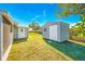 Well-maintained backyard featuring a shed, complemented by a lush green lawn and mature trees under a blue sky at 4508 26Th S Ave, Tampa, FL 33619