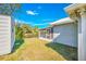 Spacious backyard with a shed, lush green lawn, and the exterior view of the house featuring a screened lanai at 4508 26Th S Ave, Tampa, FL 33619