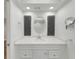 Bright bathroom featuring a modern vanity, elegant lighting, and a stylish round mirror at 4534 Great Lakes S Dr, Clearwater, FL 33762
