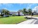 Beautiful home featuring lush green lawn, palm trees, and a colorful walkway to the entrance at 4534 Great Lakes S Dr, Clearwater, FL 33762