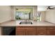 Open concept kitchen with stainless steel sink, wood cabinets and granite counters adjacent to light filled living space at 4534 Great Lakes S Dr, Clearwater, FL 33762