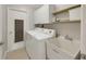 Bright laundry room with modern appliances, utility sink, and storage at 4534 Great Lakes S Dr, Clearwater, FL 33762