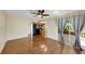 Living room with hardwood floors, ceiling fan, and view of the kitchen with black appliances at 4534 Great Lakes S Dr, Clearwater, FL 33762
