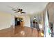 Living room with hardwood floors, ceiling fan, and view of the kitchen with black appliances at 4534 Great Lakes S Dr, Clearwater, FL 33762