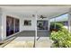 A covered patio featuring decorative stone, a ceiling fan, lighting, and access to the backyard at 4534 Great Lakes S Dr, Clearwater, FL 33762