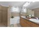 Elegant bathroom featuring a double vanity, soaking tub, tiled shower, and neutral tiling at 5634 Tanagergrove Way, Lithia, FL 33547