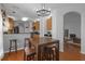 Inviting eat-in kitchen with modern chandelier, bar stool seating, and a view of the living area at 5634 Tanagergrove Way, Lithia, FL 33547