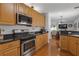 Well-equipped kitchen with stainless steel appliances, dark countertops, and light wood cabinets at 5634 Tanagergrove Way, Lithia, FL 33547