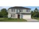 Charming two-story home featuring a red front door, light blue siding and an attached two car garage at 5656 Red Kite Dr, Wimauma, FL 33598