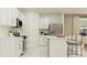 Bright kitchen features white cabinets, stainless steel appliances, and a functional center island with bar stool seating at 5656 Red Kite Dr, Wimauma, FL 33598