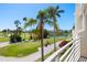Overlooking a scenic golf course and pond from the balcony, framed by mature palms and lush landscaping at 6131 Bahia Del Mar Blvd # 240, St Petersburg, FL 33715