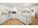 Open kitchen with white cabinets and modern appliances, seamlessly connecting to the adjacent living area at 6131 Bahia Del Mar Blvd # 240, St Petersburg, FL 33715