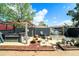 Enclosed backyard featuring a hot tub under a pergola, a stone fire pit, and a paved area at 6821 Tierra Verde St, Port Richey, FL 34668