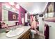 This bathroom features a unique shower curtain and a purple accent wall with white wainscoting at 6821 Tierra Verde St, Port Richey, FL 34668