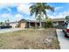 Charming single-story home featuring a well-kept front yard with mature landscaping and a spacious driveway at 6821 Tierra Verde St, Port Richey, FL 34668