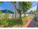 Lush backyard featuring a brick pathway, mature trees, and ample green space for outdoor activities and enjoyment at 7120 3Rd N Ave, St Petersburg, FL 33710