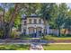 Charming two-story home with a well-manicured lawn, mature trees, and classic architectural details at 7120 3Rd N Ave, St Petersburg, FL 33710