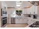 Modern kitchen features white cabinets, stainless steel appliances, and white countertops with gray subway tile backsplash at 7120 3Rd N Ave, St Petersburg, FL 33710