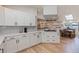 Bright kitchen features white cabinets, stainless steel hood, gray subway tile, and view into the living room at 7120 3Rd N Ave, St Petersburg, FL 33710
