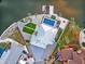 Aerial view of a waterfront home featuring a pool, landscaped yard, and a private boat lift at 744 Spanish Main Dr, Apollo Beach, FL 33572
